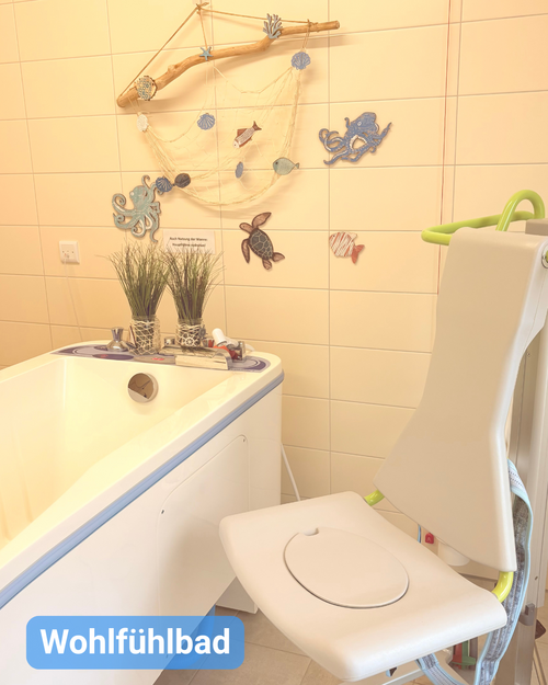Pflegebad mit Patientenlift und maritimer Dekoration. Bildbeschriftung: Wohlfühlbad
