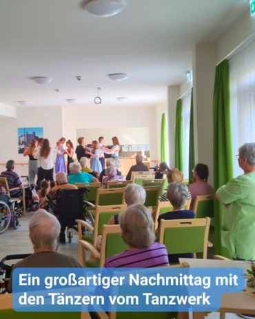 Ein hell erleuchteter Raum zeigt eine Gruppe von Senioren, die in Stühlen sitzen und mehreren jungen Menschen gegenübergestellt sind, die tanzen. Die Senioren sind in mehreren Reihen grüner Stühle platziert, einige sitzen im Rollstuhl. Sie tragen legere Kleidung.  Die jungen Tänzer befinden sich in der Nähe des Vordergrunds und scheinen mitten in einer Darbietung zu sein. Helle, grüne Vorhänge hängen in der Nähe der Fenster. Ein deutscher Untertitel am unteren Rand des Bildes lautet: „Ein großartiger Nachmittag mit den Tänzern vom Tanzwerk